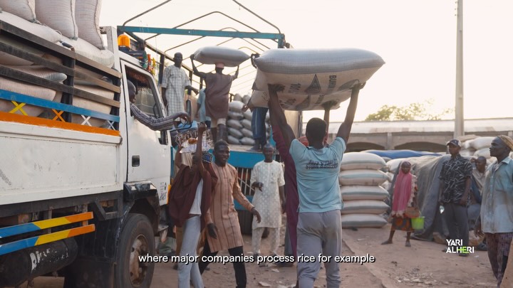 A market representative speaks among sacks of farm produce in Talata Mafara. Film still.